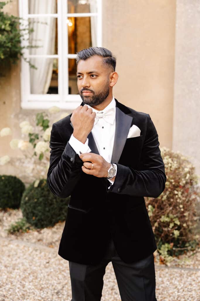 groom in black tie portrait in front of offley place
