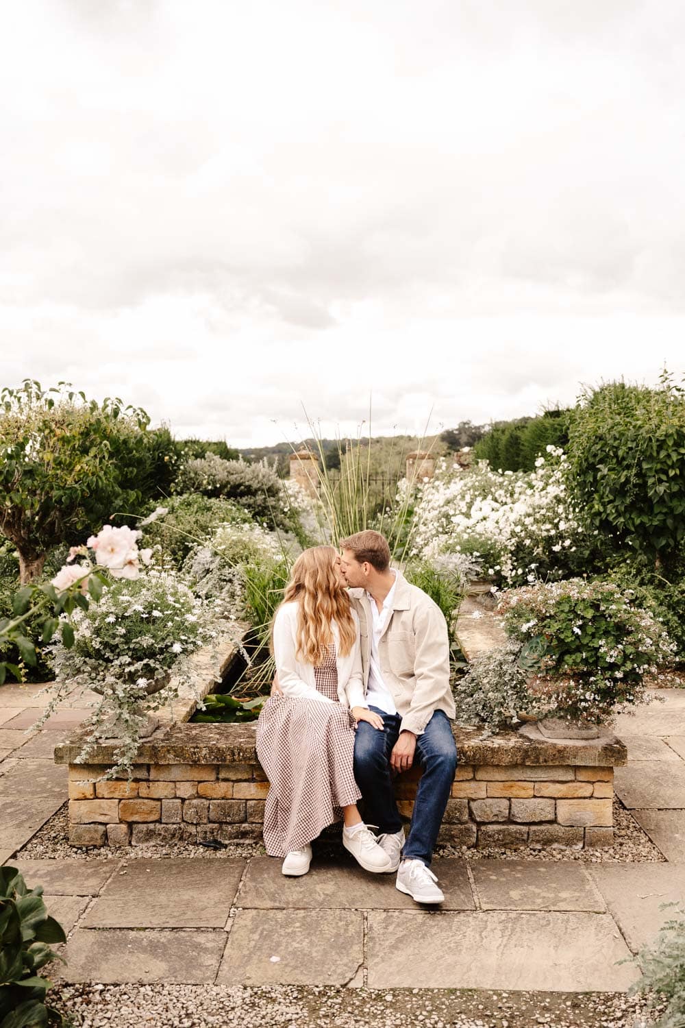 couple in bourton house gardens in the cotswolds during engagement photo shoot