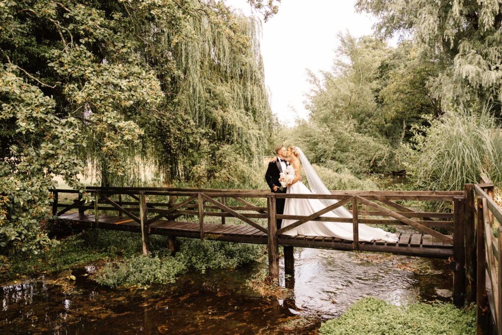bride and groom portrait on bridge at wild thyme and honey in the cotswolds