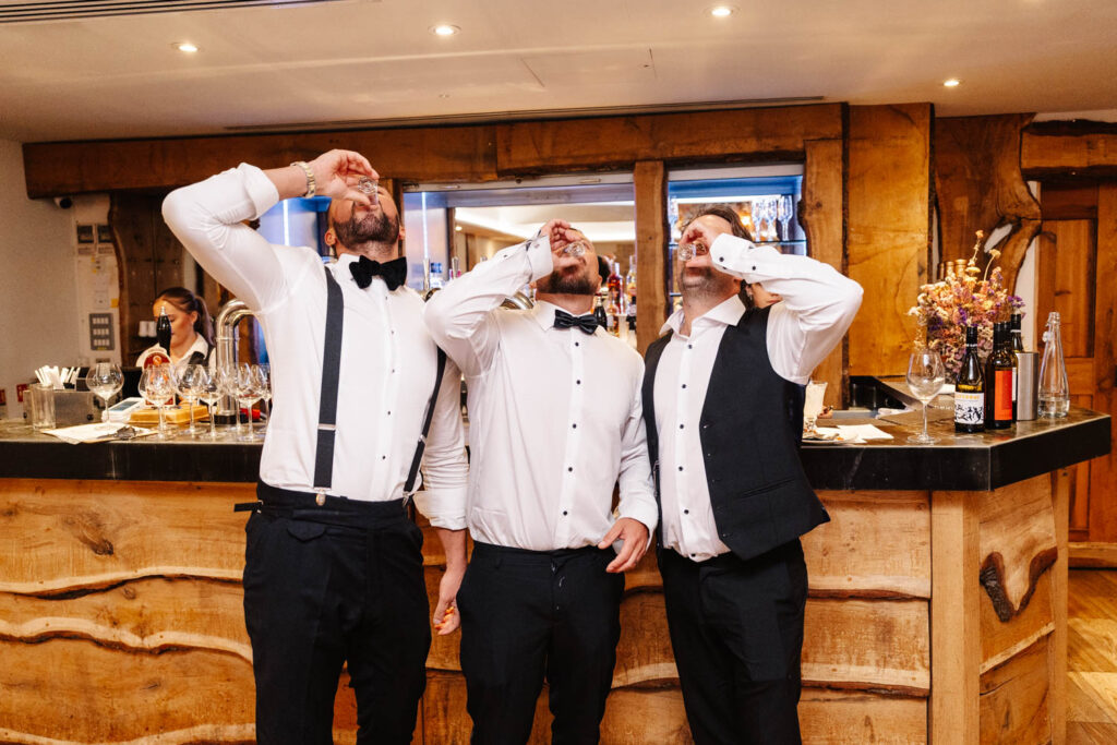 groomsmen drinking shots at wild thyme and honey in the cotswolds